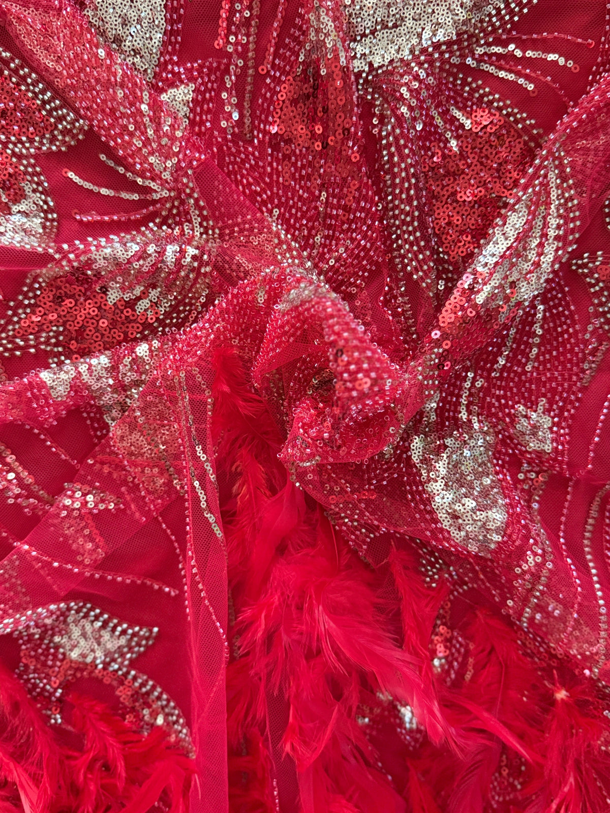 Close up of red and gold sequin embroidery with feathers on Jamar Sudanese jirtig toub