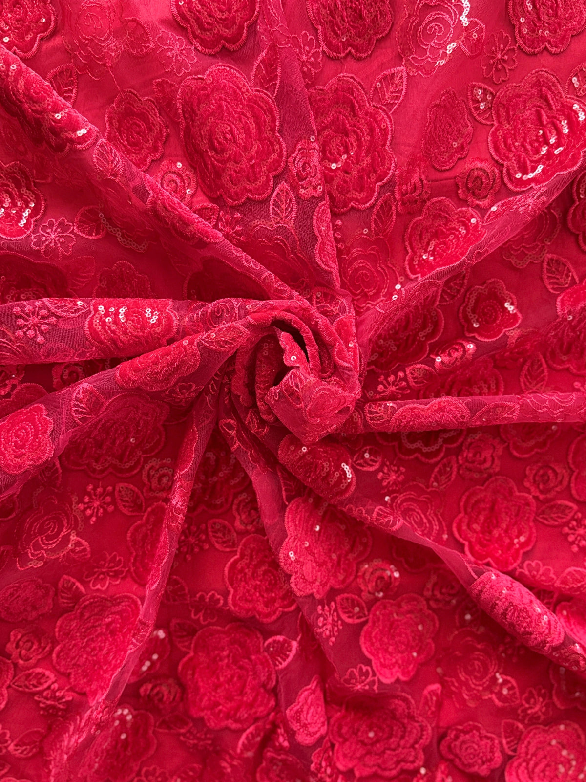Red Sudanese jirtig toub with raised floral embroidery and sequin detail, close-up