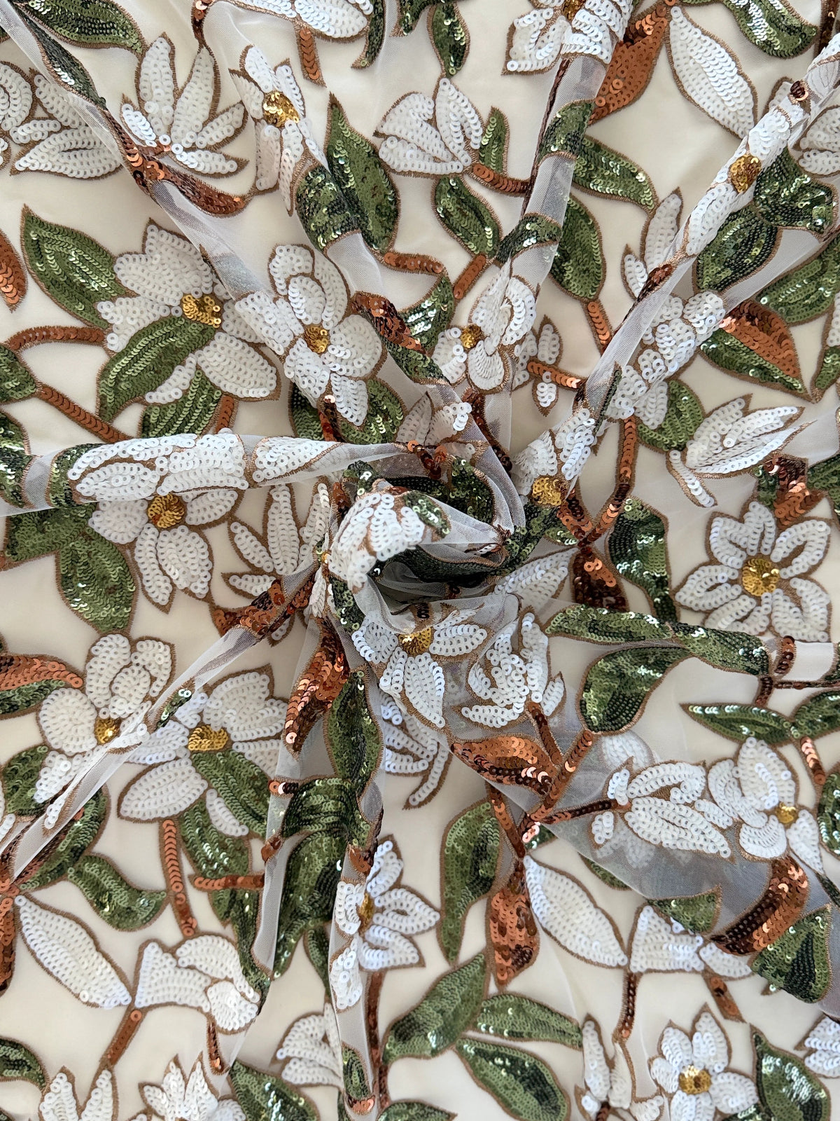 Close up of white floral and green sequin on Ward Sudanese toub