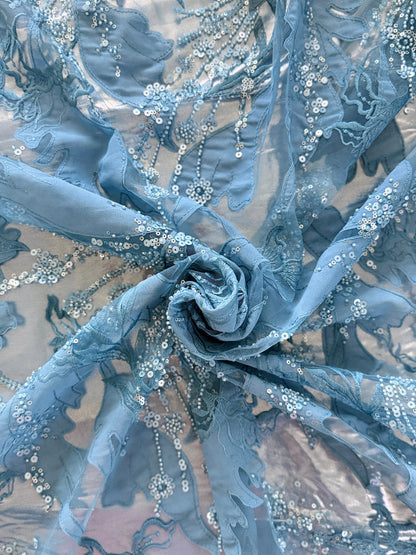 Close up of blue floral embroidery with sequin beading on Zahrah Sudanese toub